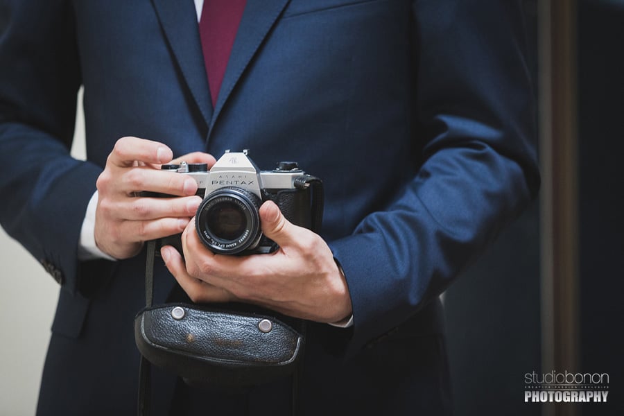 030-groom-holding-pentax-reflex-during-his-getting-ready