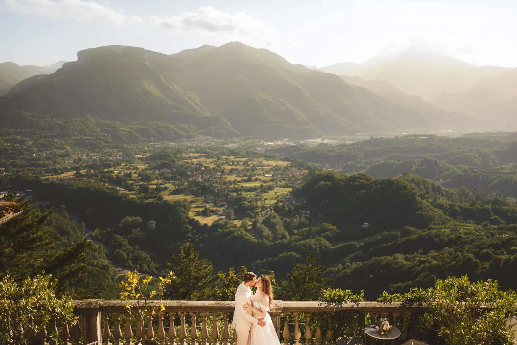 Breathtaking and elegant bride and groom photo with gorgeous panorama at Colletto Estate near Lucca in Tuscany countryside