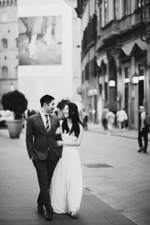 Engaged couple walks into Florence street for pre-wedding photo shoot