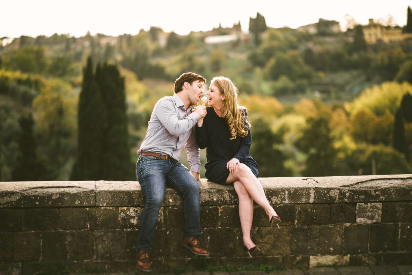 Smiling and lovely couple is enjoying ice scream during Florence engagement photo shoot at Piazzale Michelangelo
