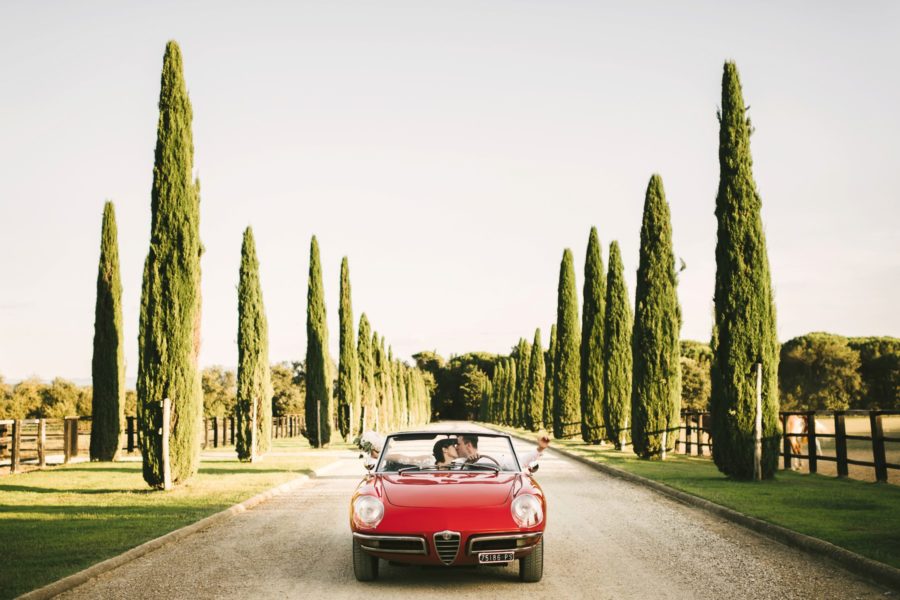 Bride and groom special kiss on Alfa Romeo vintage car in cypress road near Montelucci Country Resort