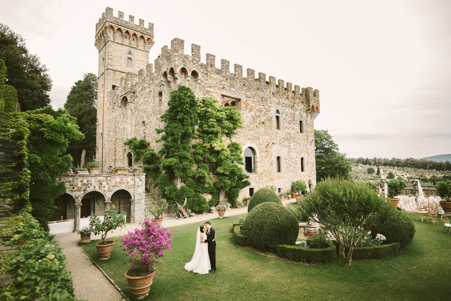 Lovely bride and groom portrait in Vincigliata medieval Castle near Florence. Destination multicultural civil castle wedding in Tuscany countryside