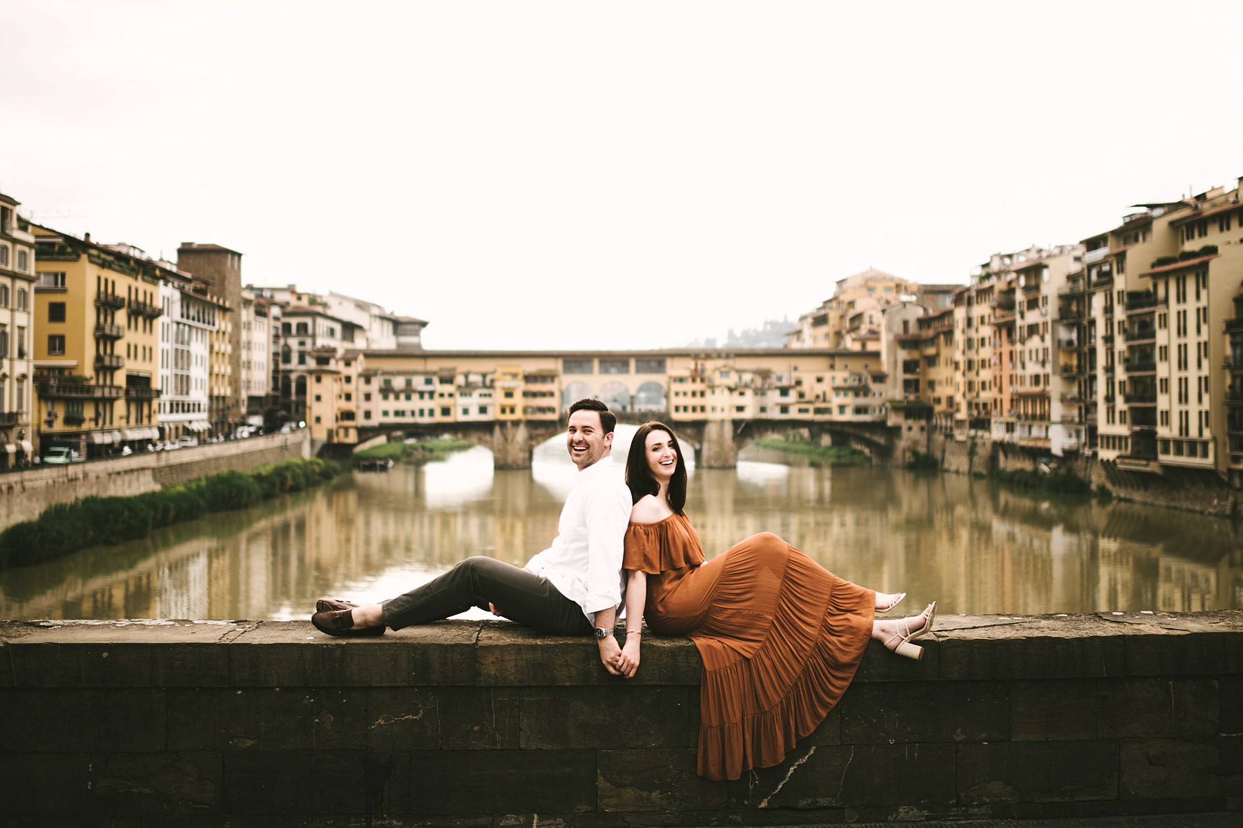 Creative and fun couple engagement photo shoot near Old Bridge in Florence. Sunrise photo session with no tourists down the streets