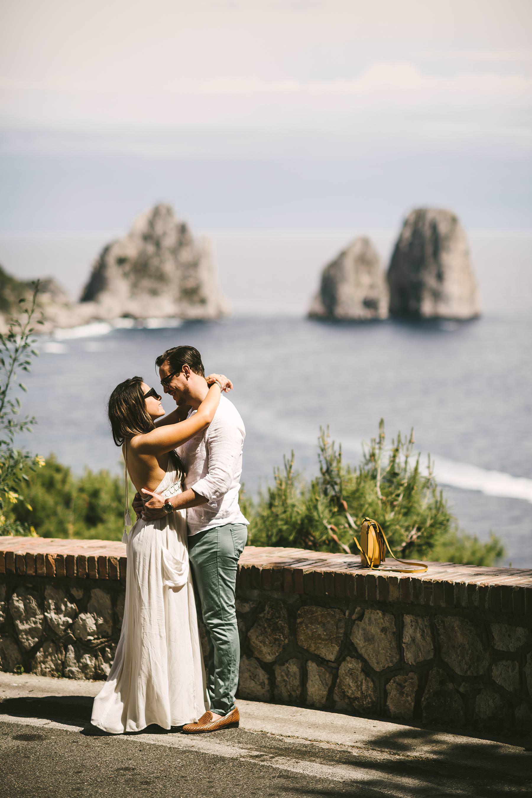 Couple portrait engagement pre-wedding photo session in a scenic road with breathtaking sea stacks of Capri island