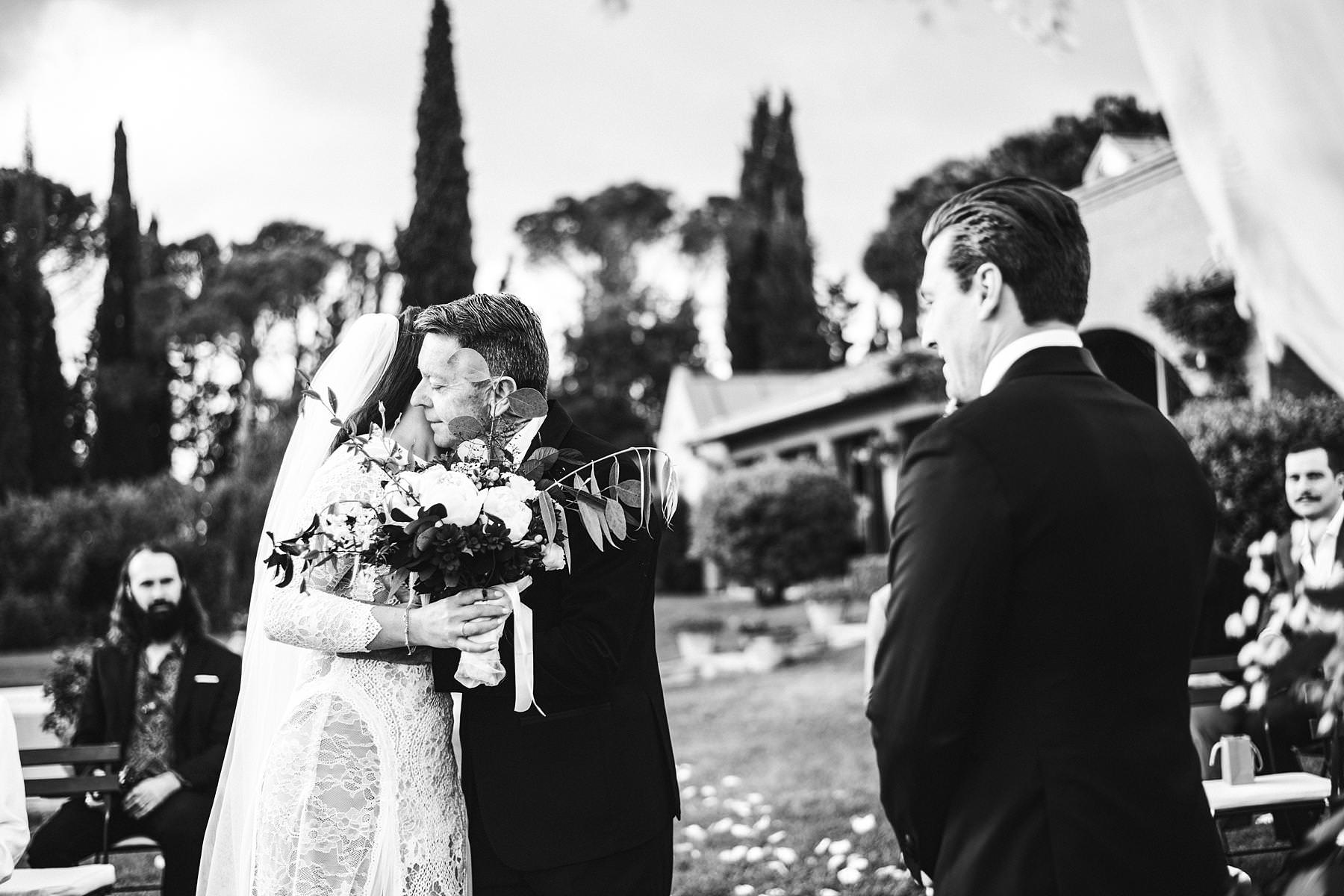 Bride Holly in Grace Loves Lace wedding dress walks down the aisle with her father in intimate destination wedding in Umbria at incredible historic venue Villa l'Antica Posta