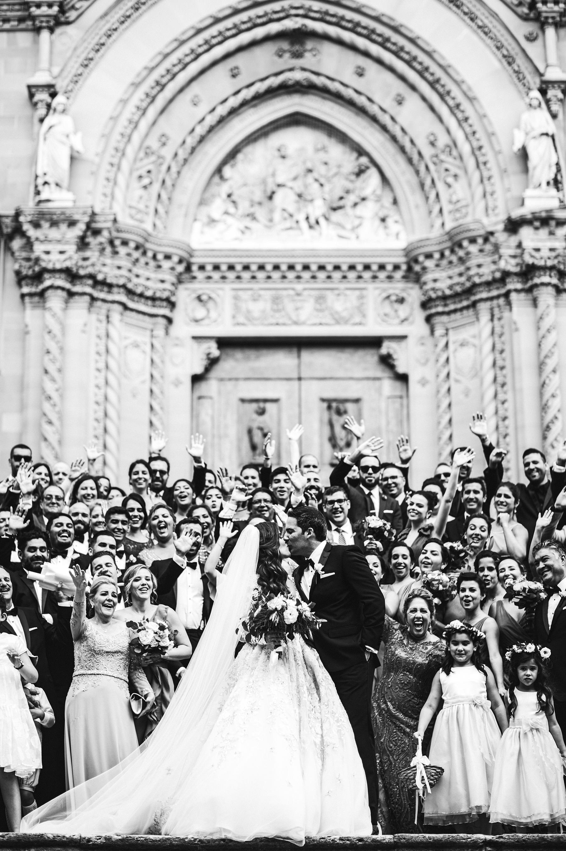 Rippling and sumptuous Tuscany wedding in the elegant Castle of Valenzano. Elegant and exciting bride and groom group photo at Arezzo Cathedral