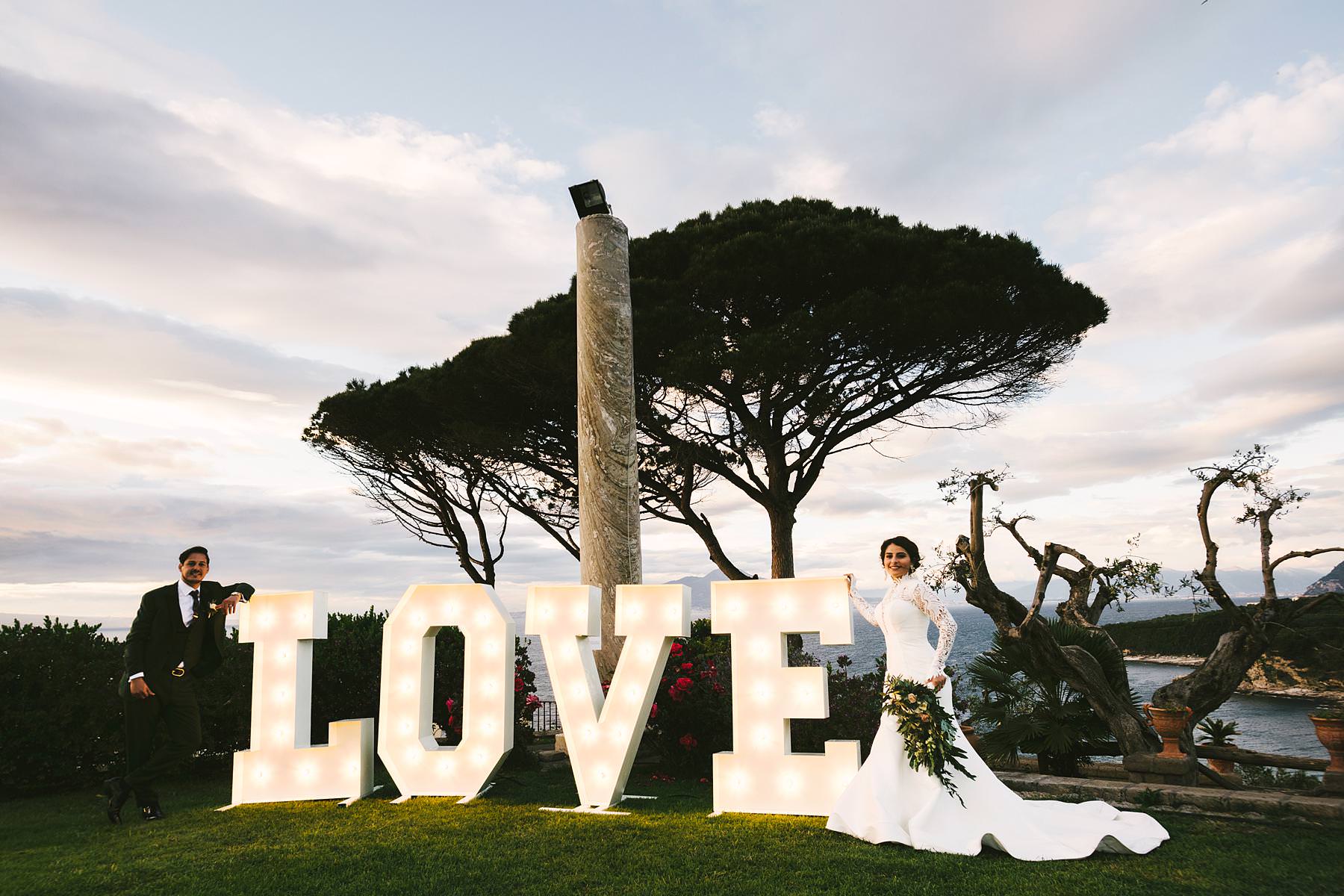 Amazing bride and groom portrait with the "love" sign at Villa Angelina venue