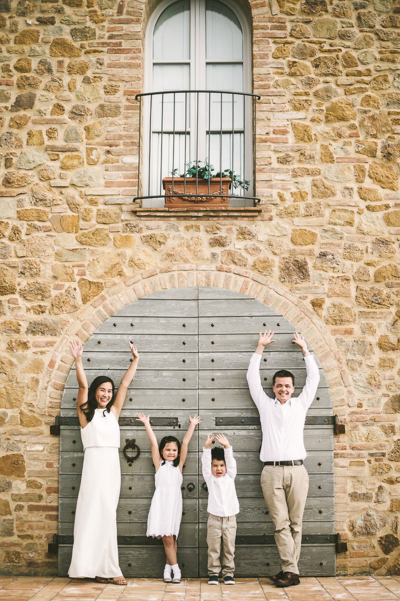 Exciting and fun summer family vacation photo shoot in Tuscany countryside. Mom, dad and kids are enjoying some time during the photo session