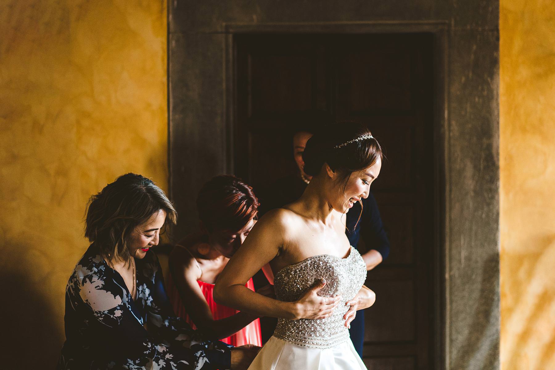 Beautiful moment bride getting dress at Palagio Castle. Intimate destination wedding in Tuscany