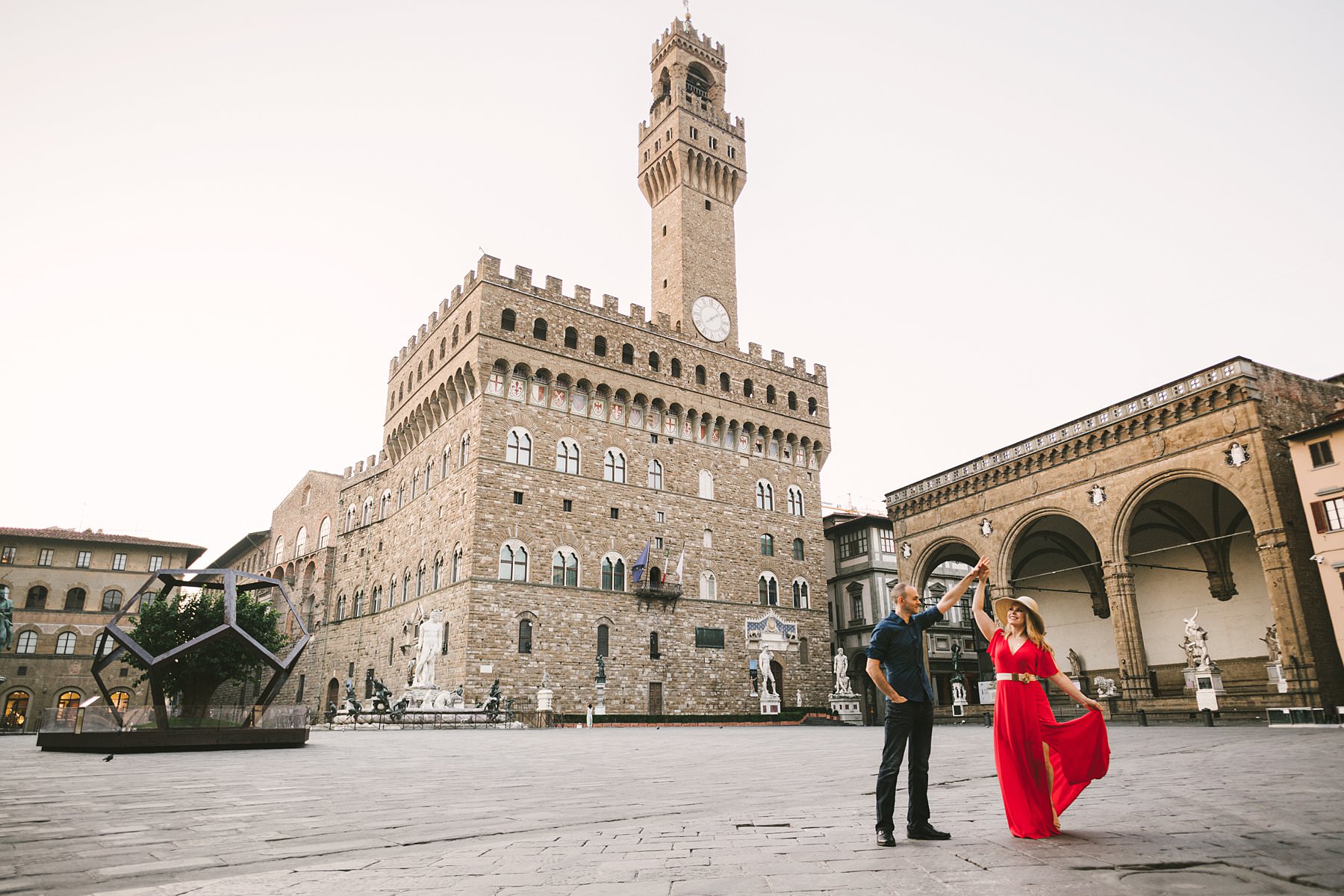 Anniversary photos in Florence, soft as sunrise, red as passion. A beautiful frame, a delicate light, a bright red dress, a milestone to celebrate: these were the ingredients of Anisa and Kevin’s anniversary photos, taken in Florence at sunrise. We strolled the streets of the city, during a session that lasted almost three hours and touched all of the most iconic spots: from Piazza della Signoria to the Uffizi Gallery, from Palazzo Gondi to Piazza S. Firenze, from Ponte Vecchio to Piazzale Michelangelo. The latter is a truly enchanted place from which you can enjoy a breathtaking view of the city: the most wonderful photo setting anyone could ask for