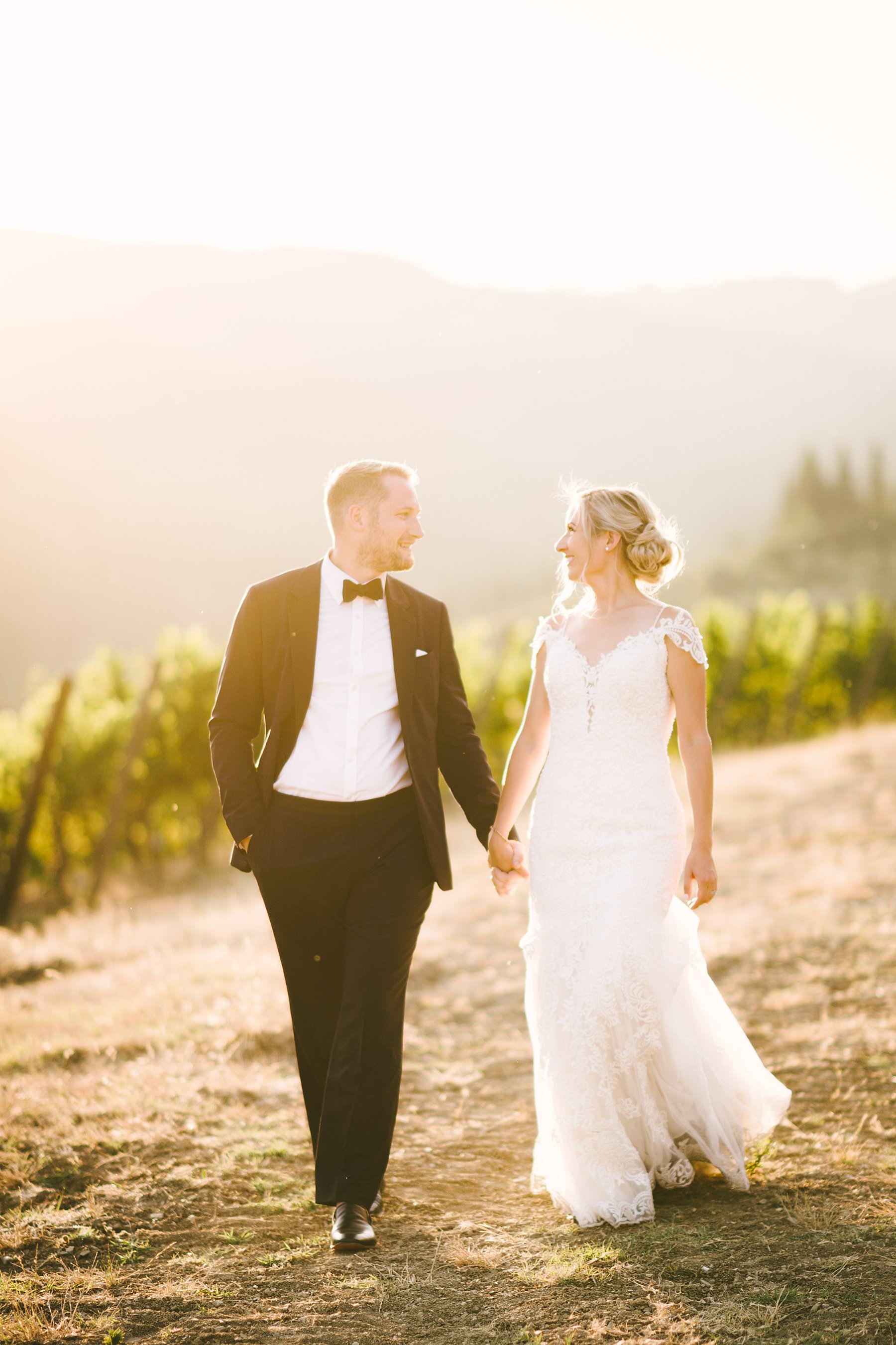 Romantic wedding in Italy at the charming Castello del Trebbio. Dreamy and unforgettable bride and groom wedding portrait during golden hour in the vineyard of the countryside of Tuscany at Castello del Trebbio