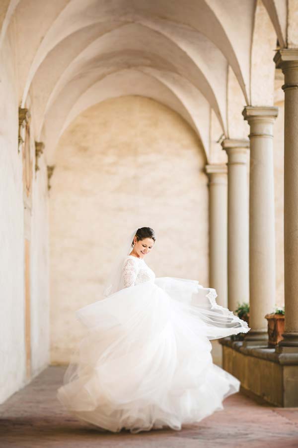 Beautiful and amazing bride in Atelier Eme wedding dress under the archway of Certosa di Firenze church