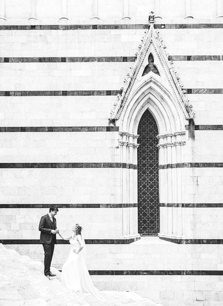 Getting married in Italy, surrounded by beauty. Bride Poppy and groom Chris elopement photo near the Duomo of Siena, Tuscany
