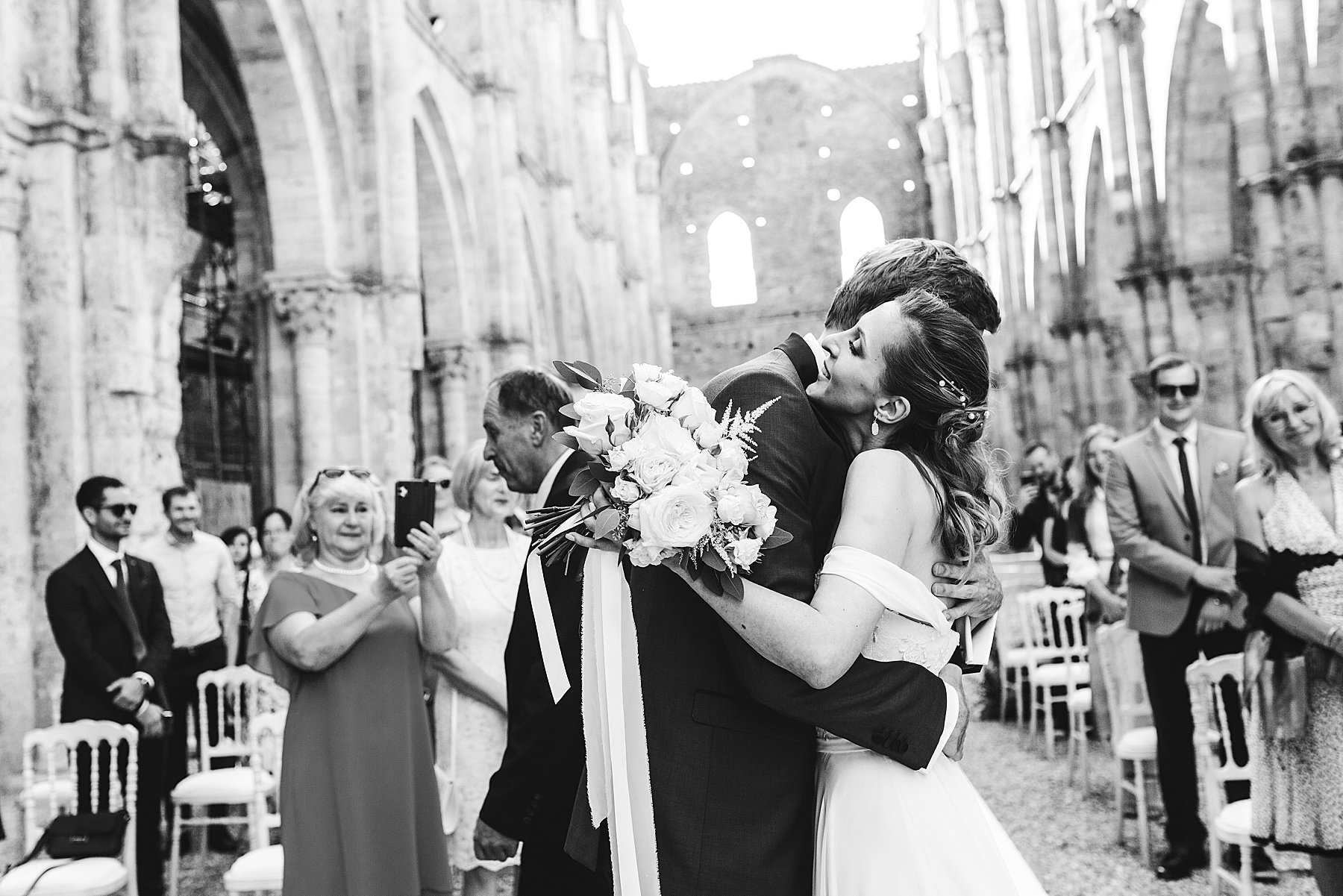Emotional moment during ceremony at San Galgano Abbey. Intimate destination wedding in Tuscany near Siena