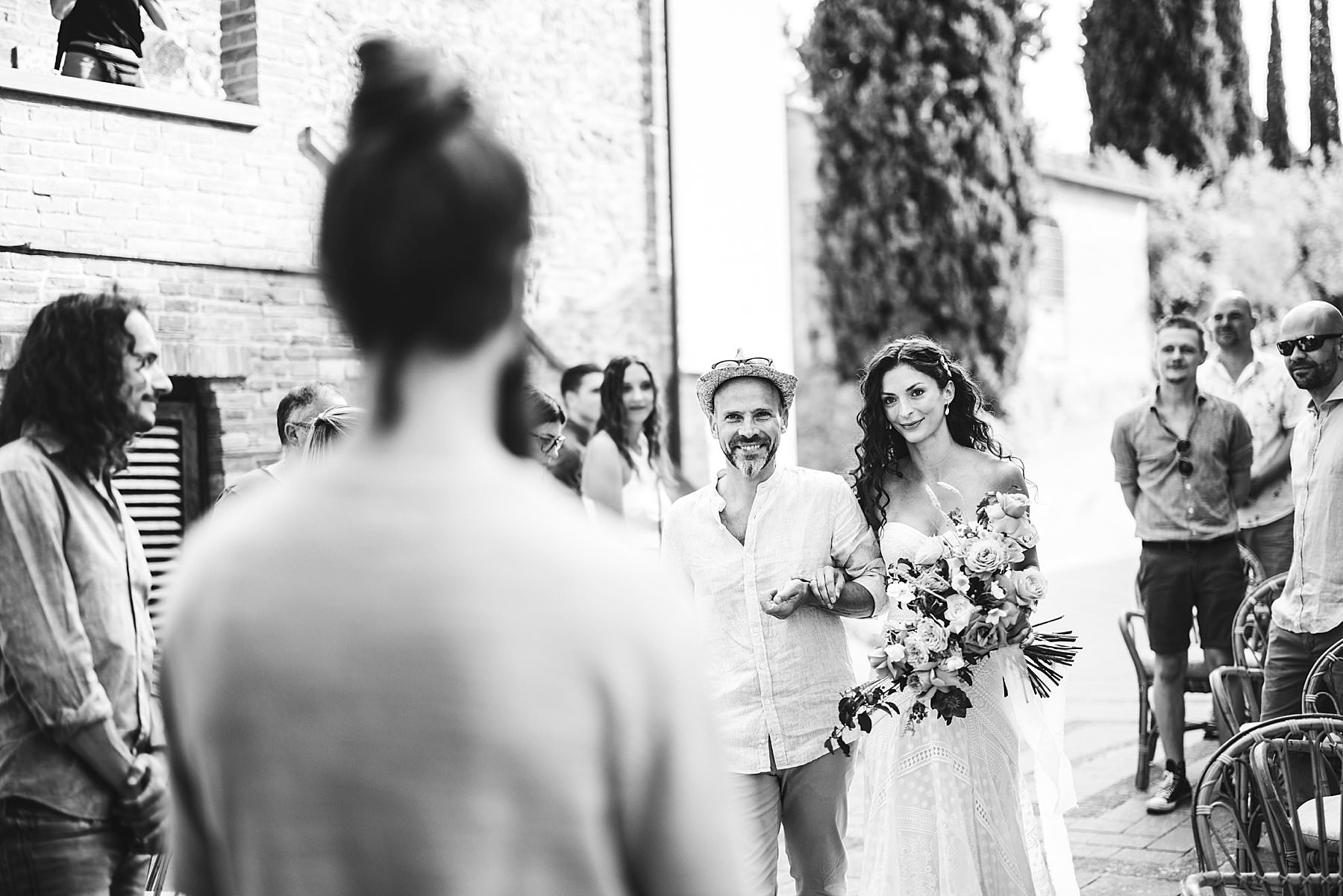Elegant and sweet bride walks down the aisle of her boho chic intimate wedding in Tuscany at La Valle farmhouse in Montaione