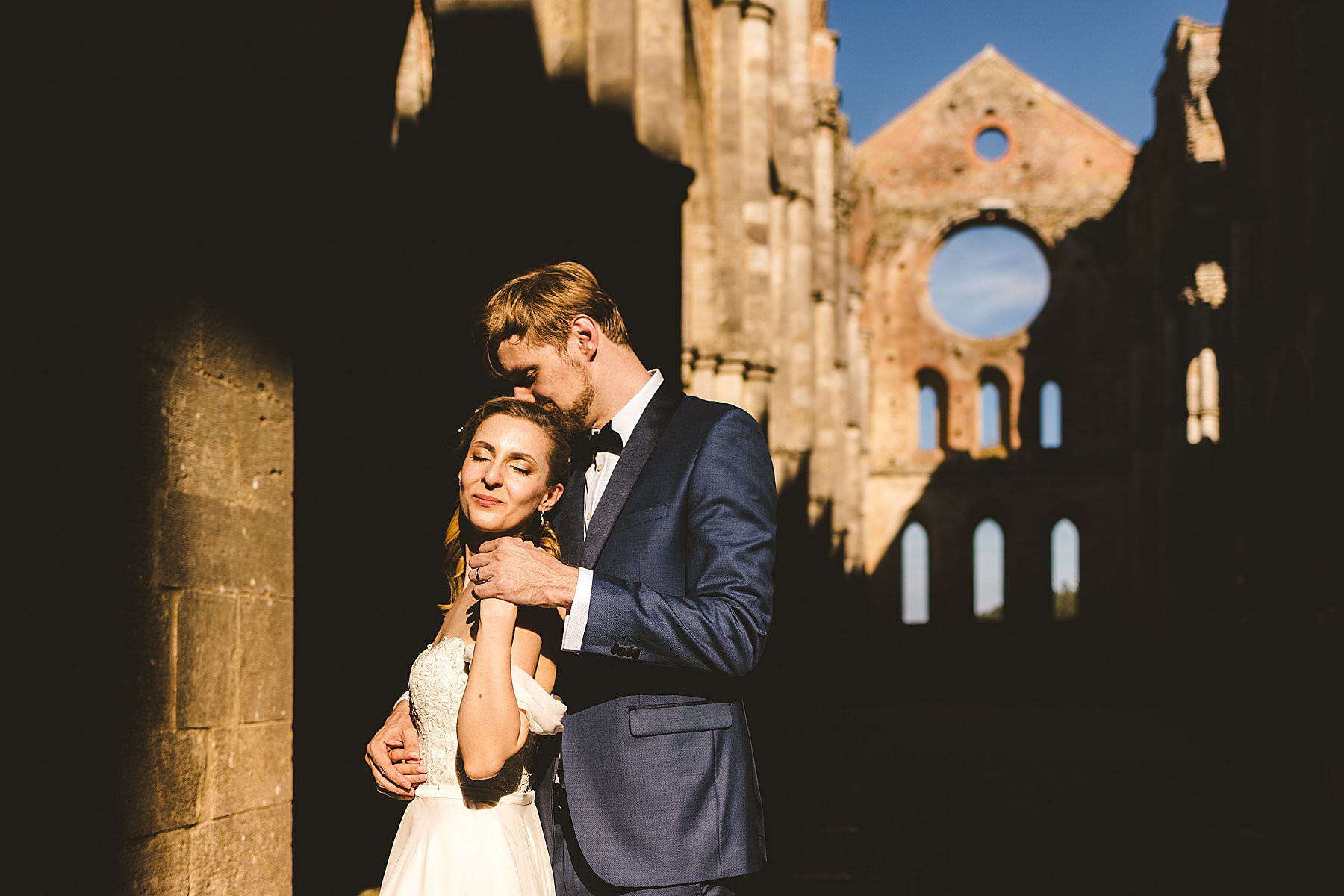 Lovely and romantic couple wedding photo inside the Roofless Abbey of San Galgano Church near Siena
