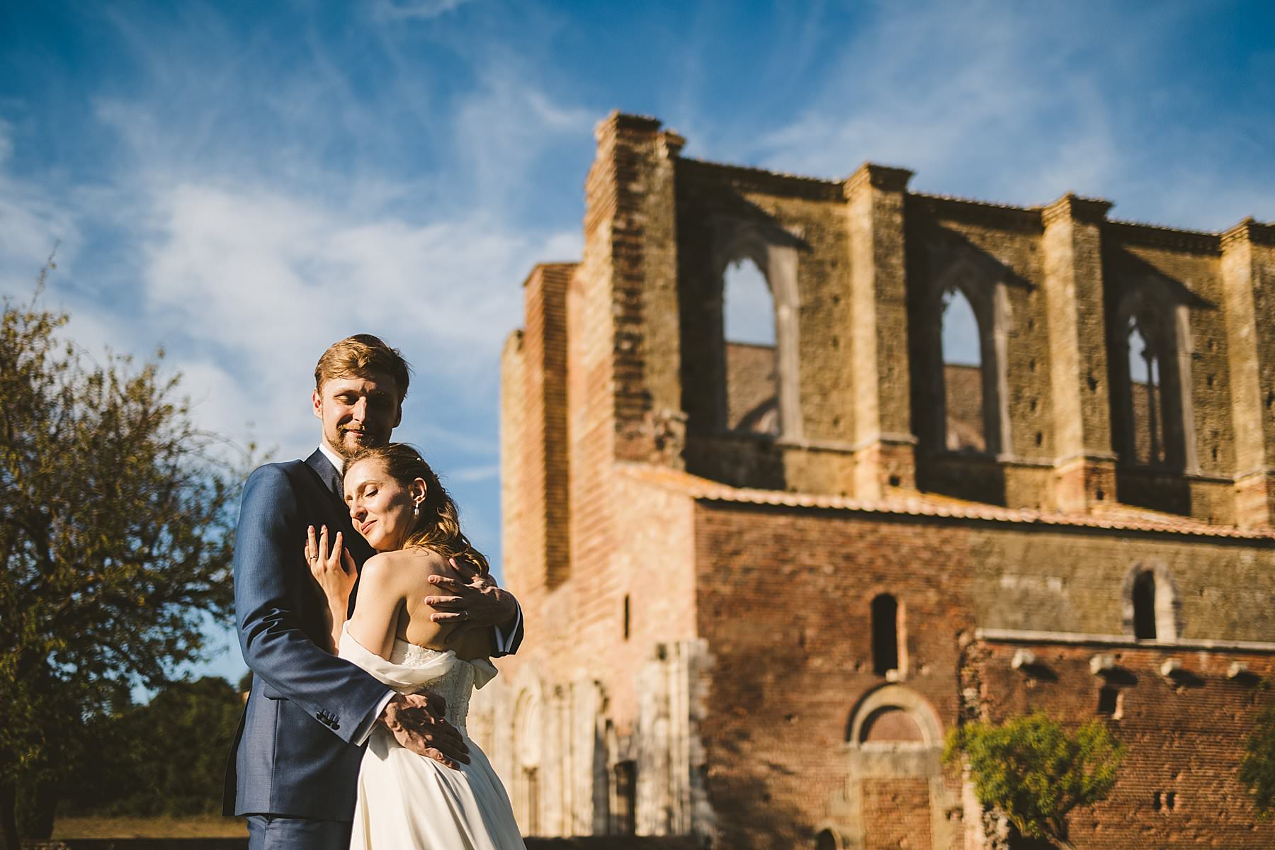 Romantic bride and groom wedding photo in the countryside of Tuscany wedding at Roofless Abbey of San Galgano