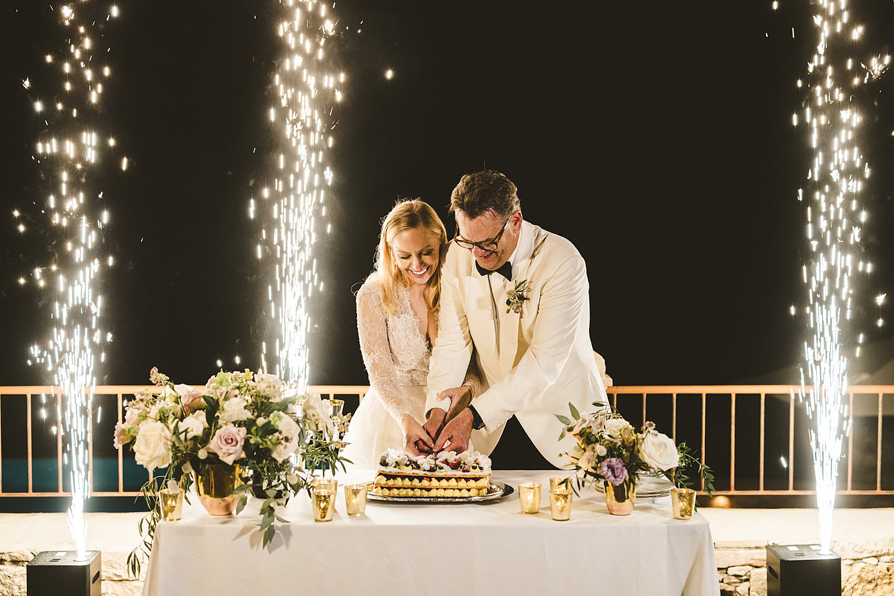 Lovely and unforgettable elopement wedding cake cutting with sparkling lights at Borgo Pignano