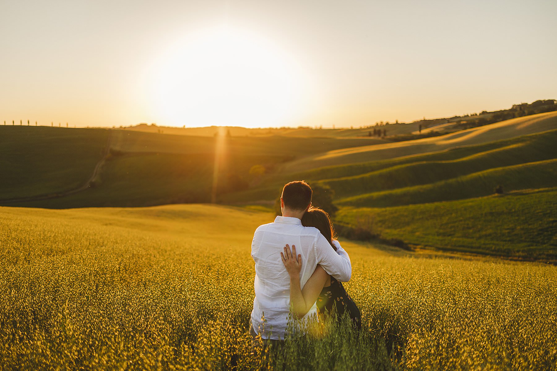 Evocative sunset engagement photos in the magic countryside of Pienza during golden hour