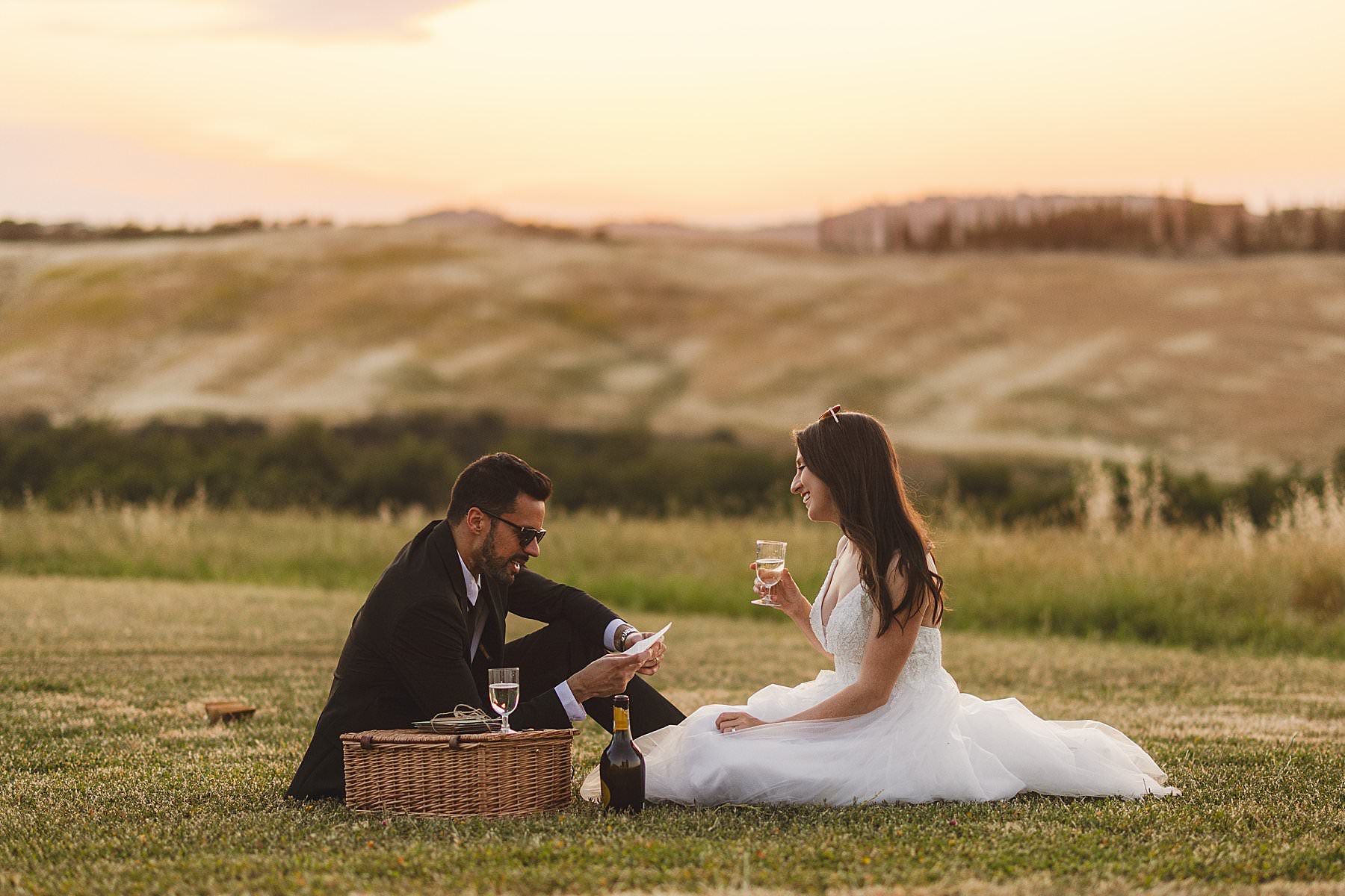 Exciting bride and groom elopement celebration in the golden hour light in the countryside of Tuscany at Vitaleta Chapel near Pienza