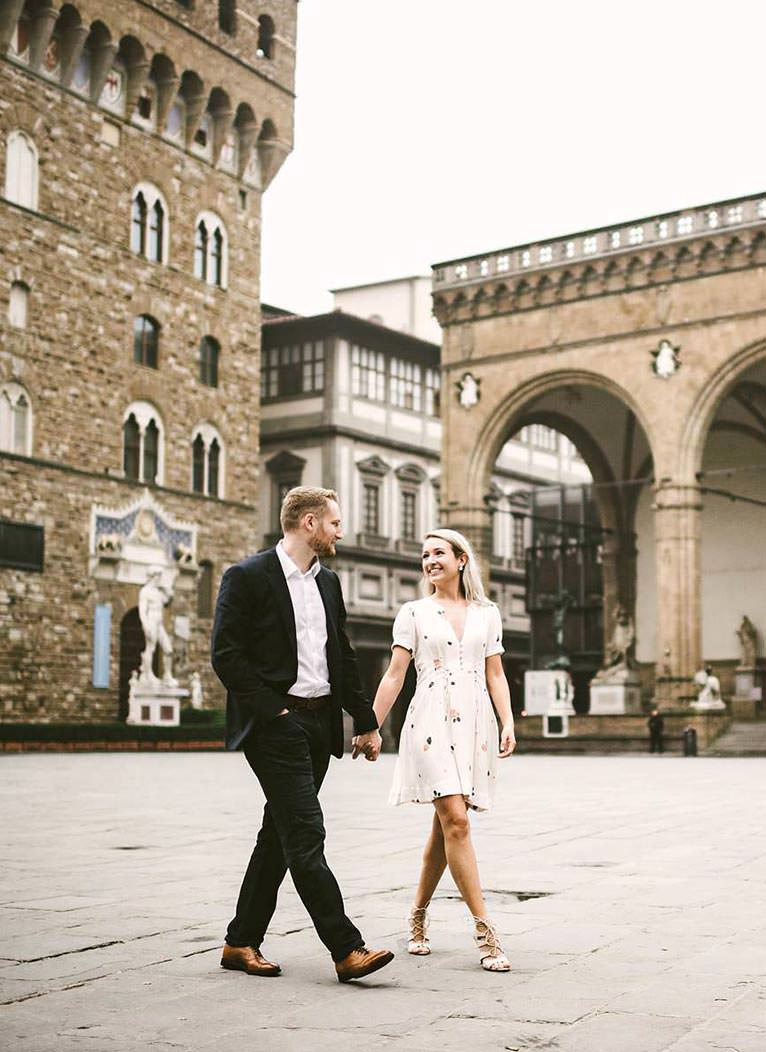 Lovely couple engaged in Florence. Pre-wedding couple portrait photo shoot at Piazza della Signoria square near Palazzo Vecchio