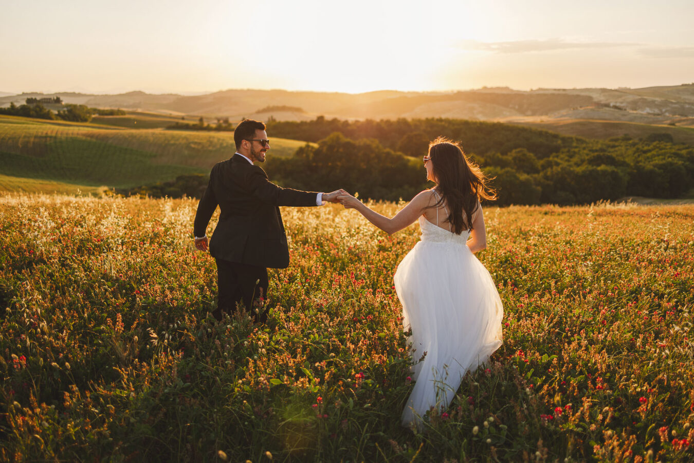 Exciting bride and groom elopement wedding portrait in the golden hour light in the heart of Tuscany countryside near Pienza