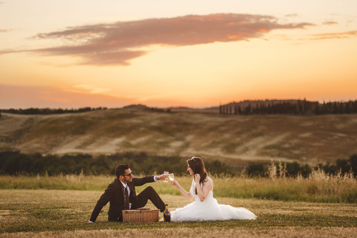Exciting bride and groom elopement celebration in the golden hour light in the countryside of Tuscany at Vitaleta Chapel near Pienza