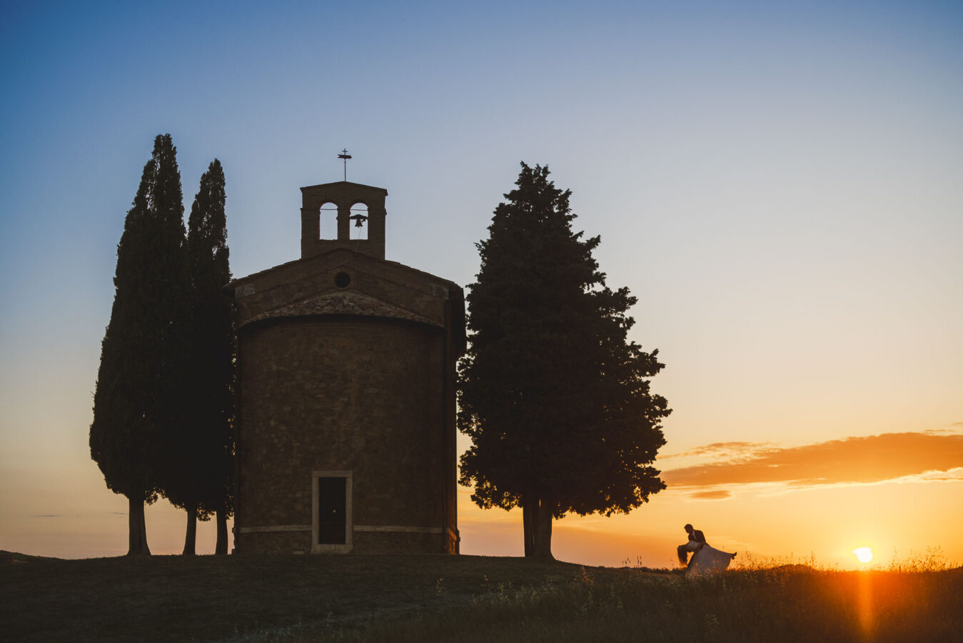Unforgettable bride and groom elopement photo at Vitaleta Chapel near Pienza in the Val d’Orcia Tuscany with gorgeous sunset