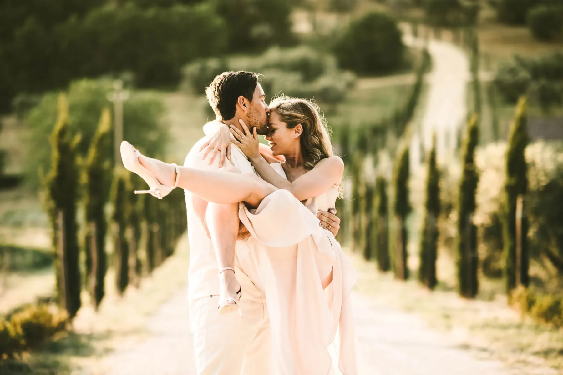 Dreamy Italy elopement with vows renewal in Val d'Orcia. Unforgettable couple portrait photo with cypresses street and rolling hills typical of the Tuscany countryside of Pienza