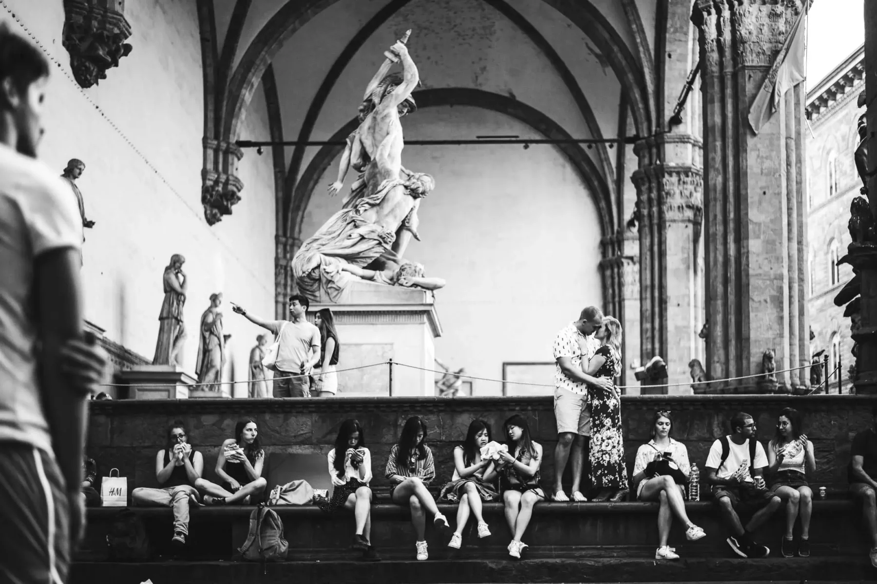 Lovely couple portrait in Florence at Loggia Lanzi museum near Palazzo Vecchio in Piazza della Signoria. Romantic photo session to commemorate and celebrate the love