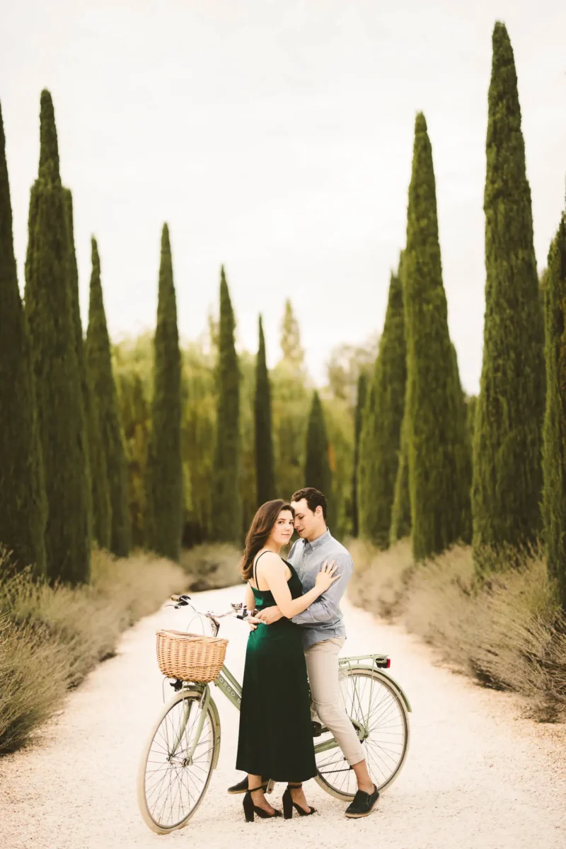 Romantic and candid engagement photos in Tuscany in the evocative cypresses street of luxury Borgo Santo Pietro resort