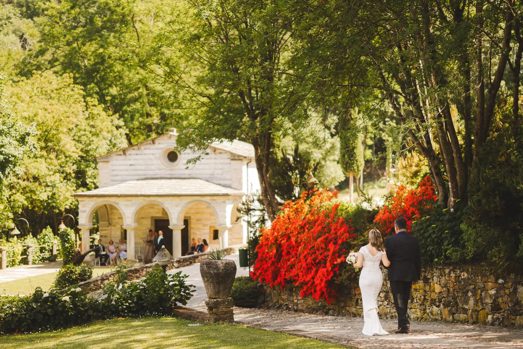 Lovely bride walks into outdoor destination wedding ceremony at luxury borgo Valle di Badia in Tuscany