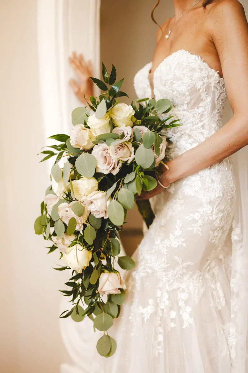 Elegant and lovely detail of bride with flower bouquet made by roses