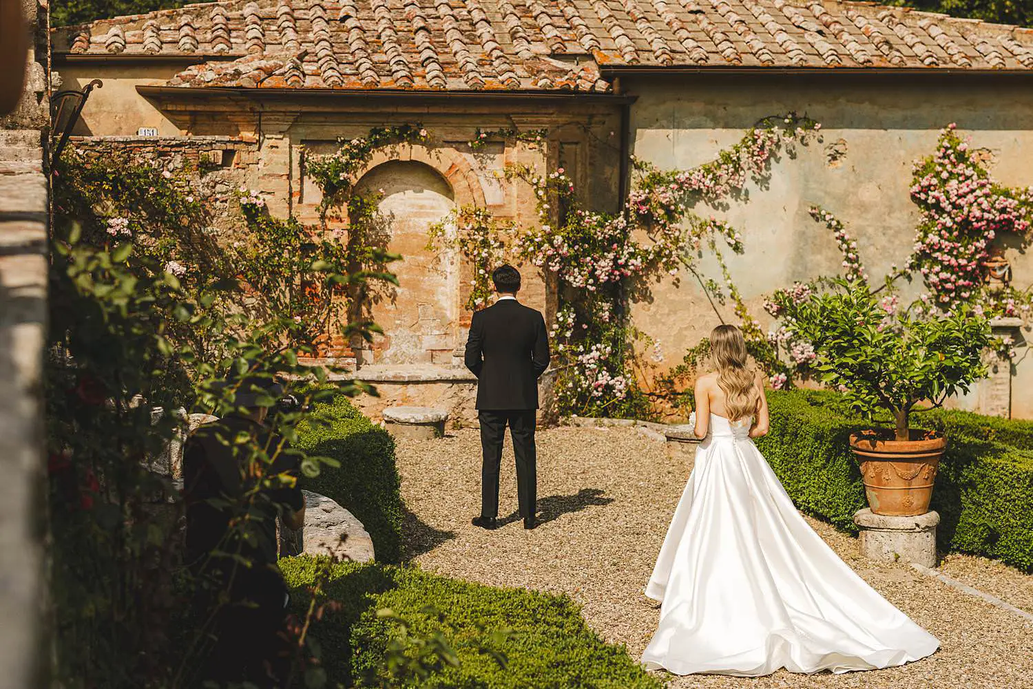 An unforgettable first look moment between the bride and groom in the refined garden park of Castello di Celsa, Tuscany