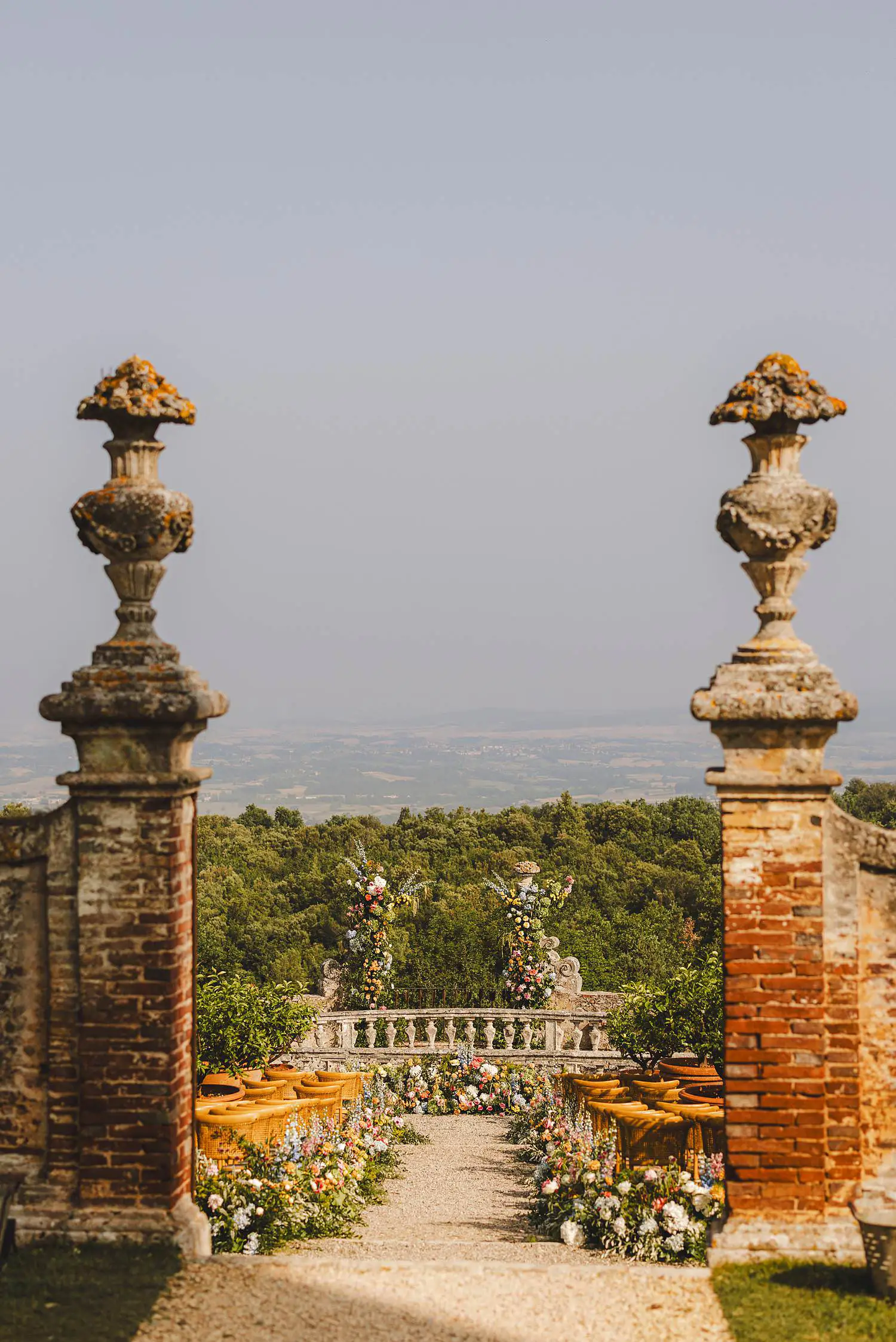 Elegant and colourful wedding ceremony setup in the garden of ancient Castello di Celsa in Tuscany