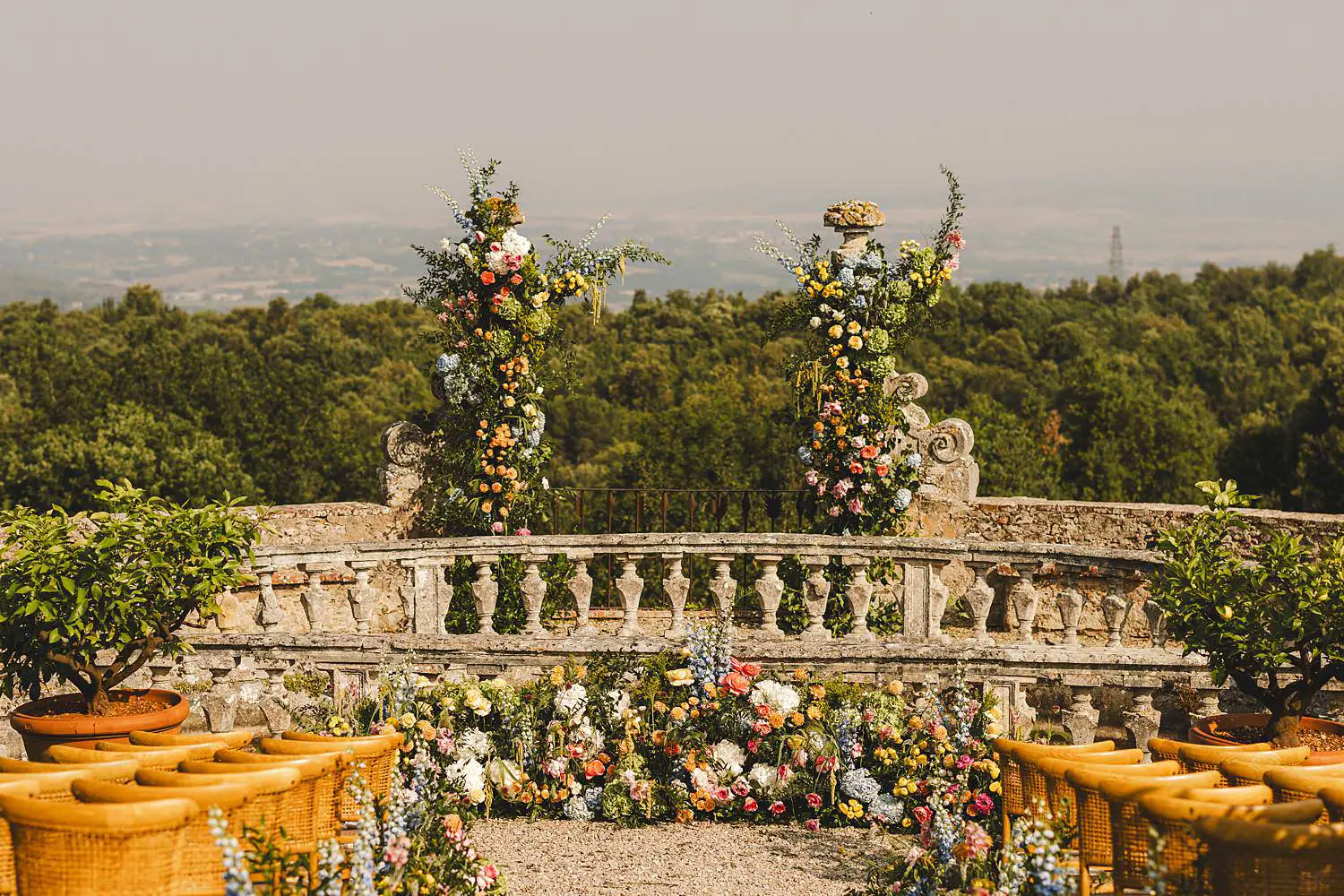 Elegant and colourful wedding ceremony setup in the garden of ancient Castello di Celsa in Tuscany