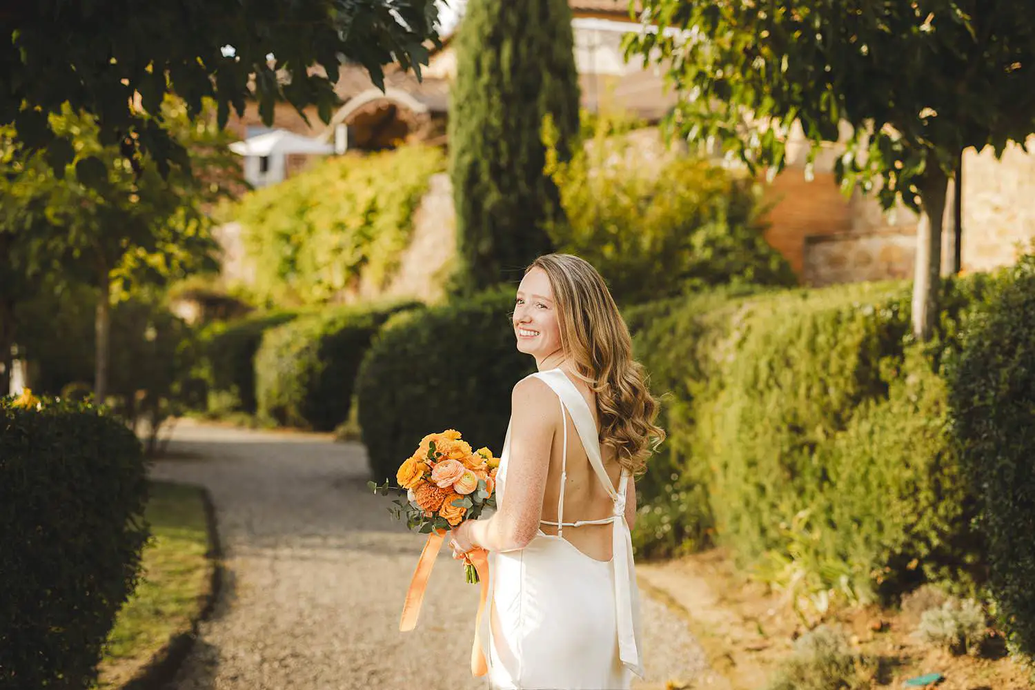 Capturing bride portrait against rustic stone architecture at Borgo di Petrognano for a joyful same sex wedding in Tuscany