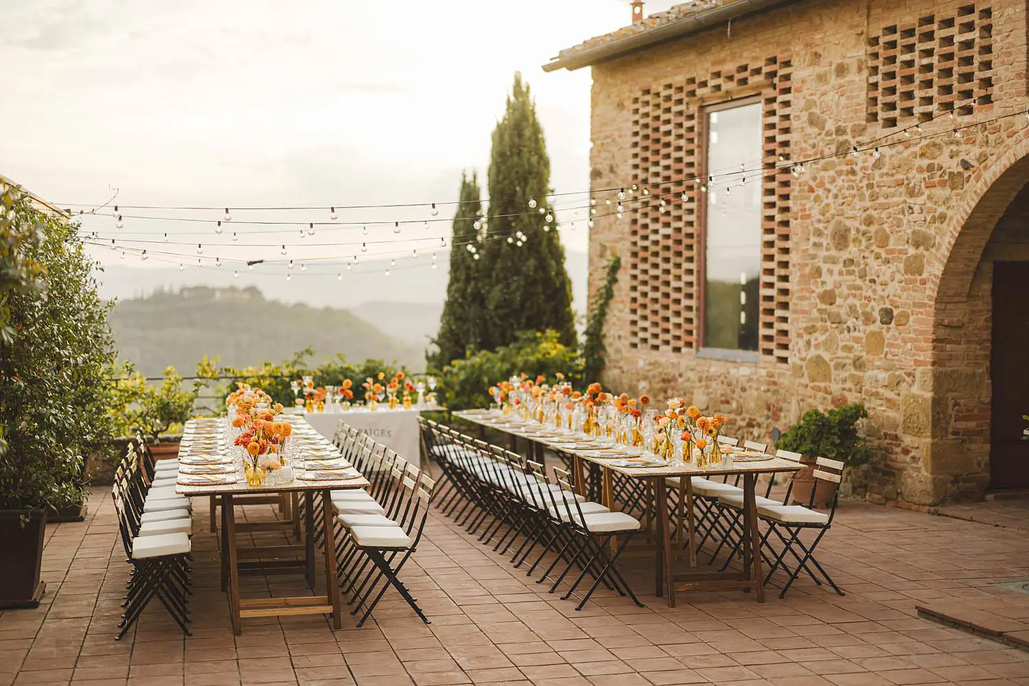 Elegant wedding dinner table decoration with warm seasonal florals in shades of orange at Borgo di Petrognano