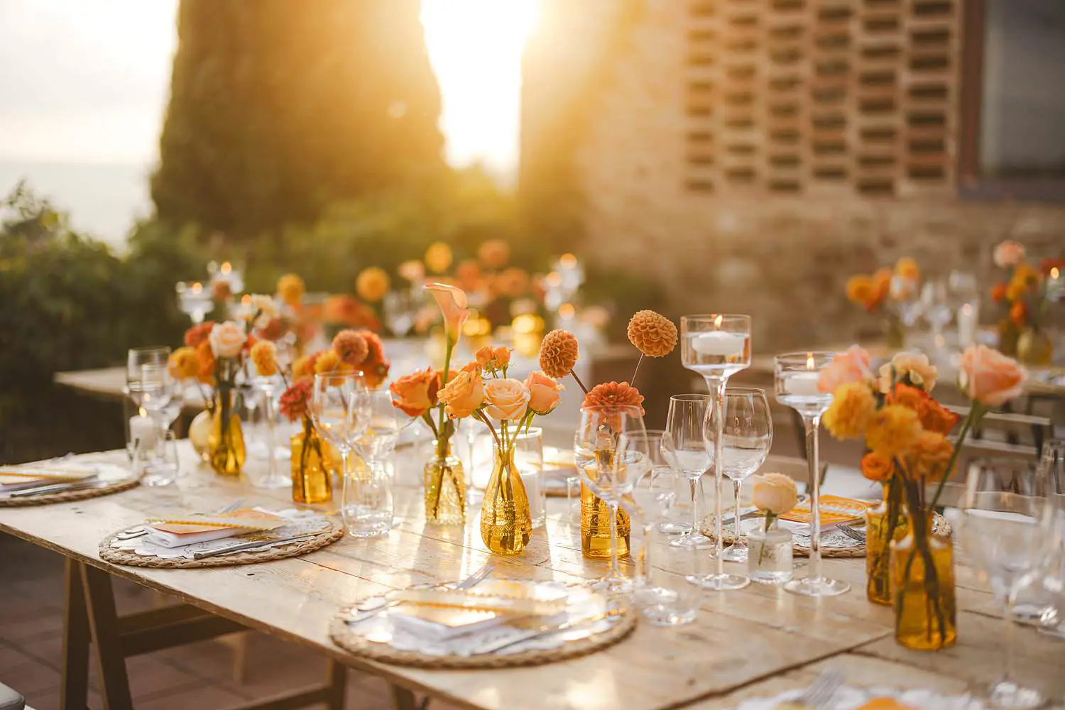 Elegant wedding dinner table decoration under Tuscan golden light with warm seasonal florals in shades of orange at Borgo di Petrognano