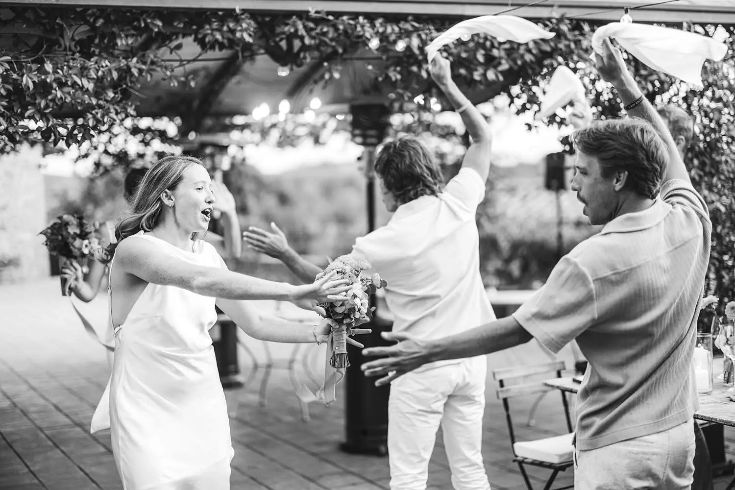 Same sex brides make a joyful entrance to dinner, greeted by applause, laughter and waving napkins at Borgo di Petrognano