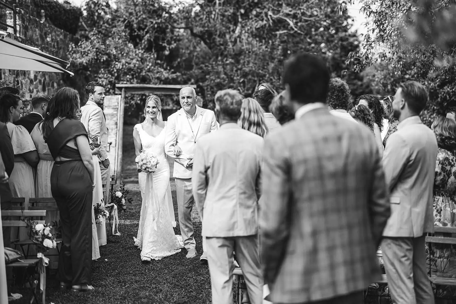 Lovely bride and father walk in the outdoor wedding ceremony at Agriturismo Quercia al Poggio