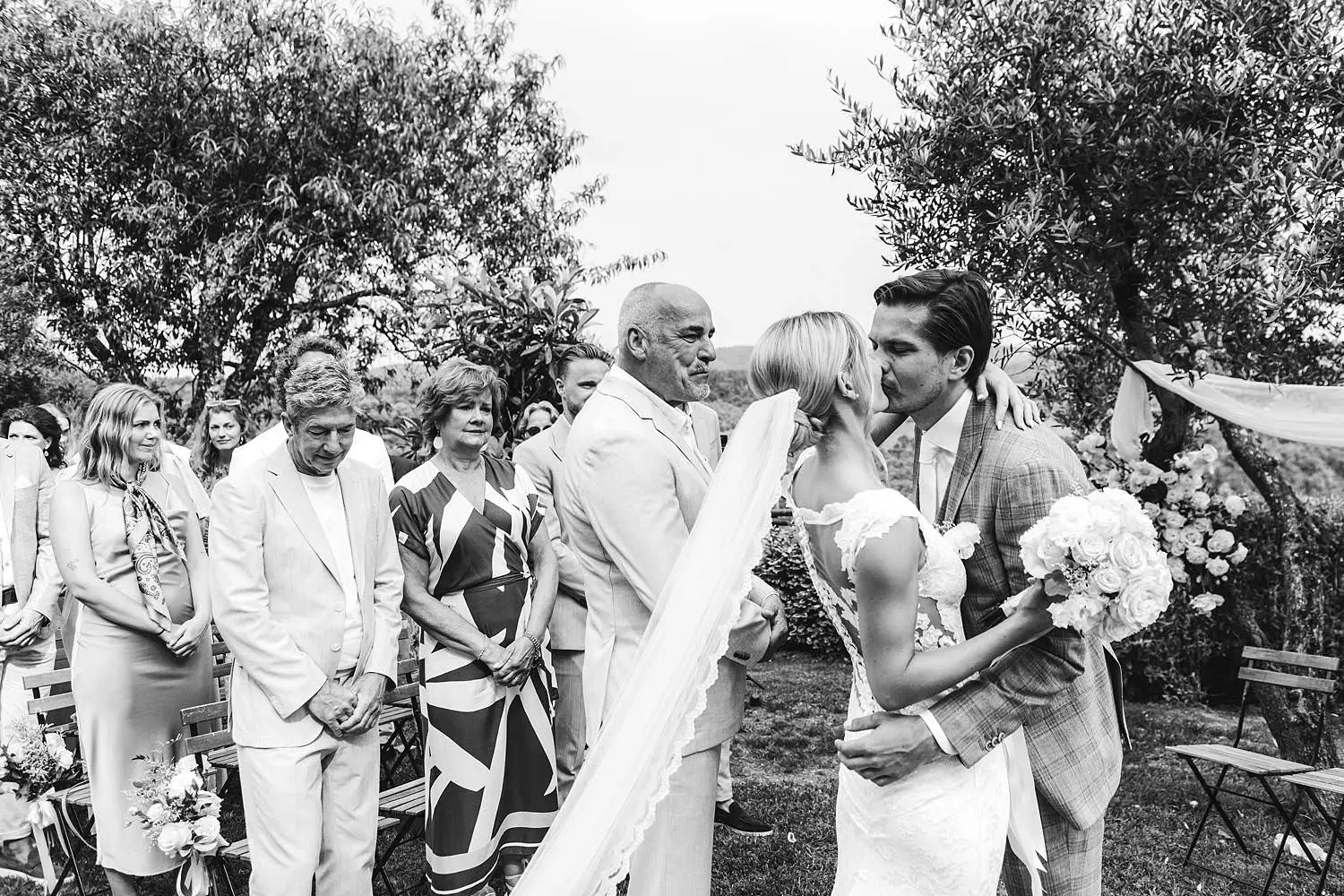 Emotional bride and father walk in the outdoor wedding ceremony at Agriturismo Quercia al Poggio