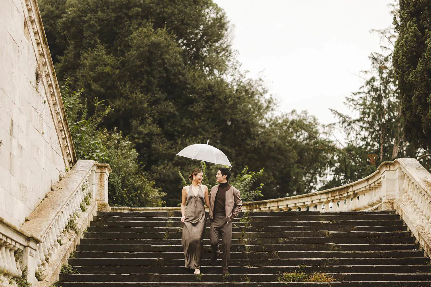 Candid and spontaneous engagement photo shoot in Florence under the rain with transparent umbrella