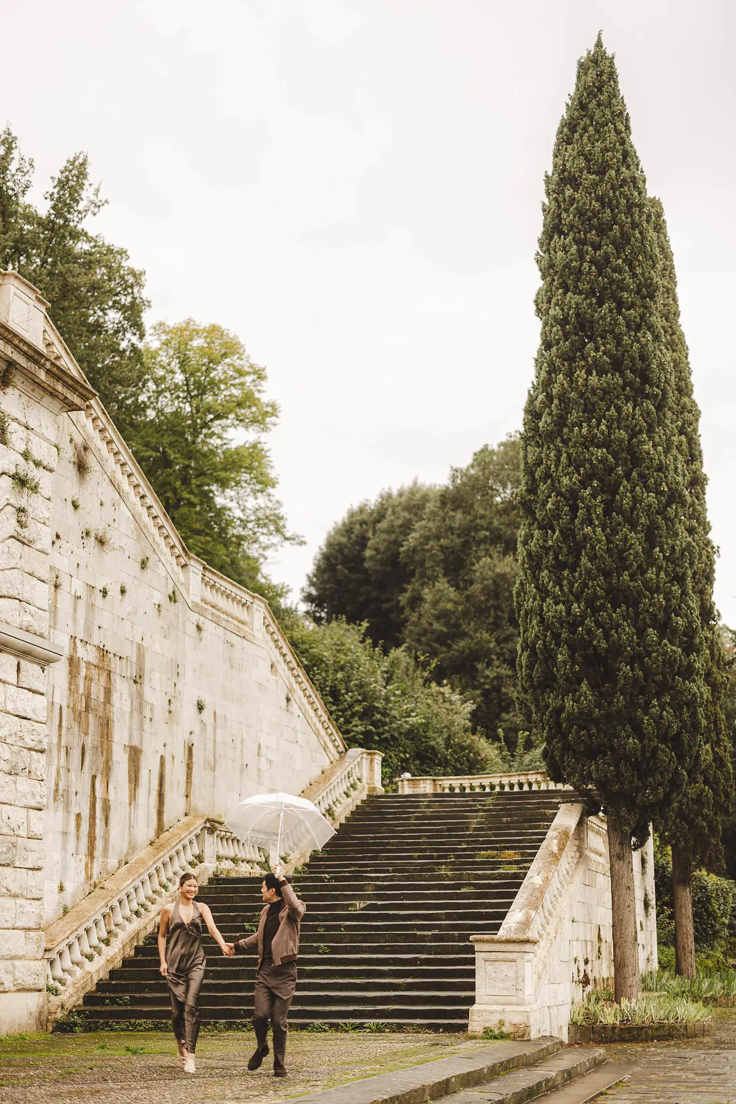 Candid and spontaneous engagement photo shoot in Florence under the rain with transparent umbrella