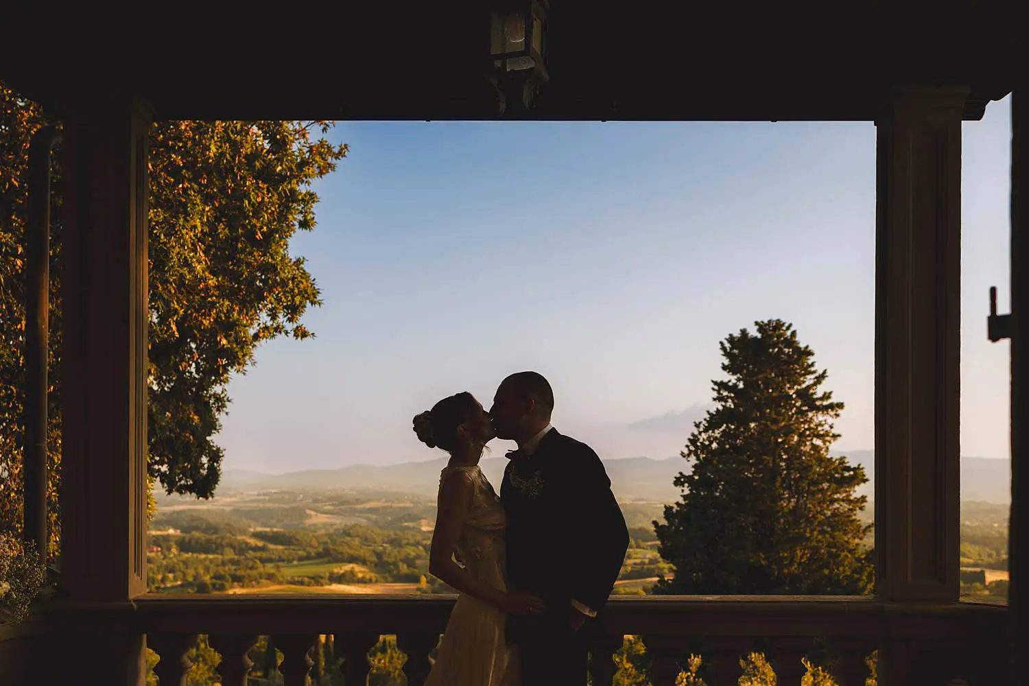 Bride and groom wedding photo while enjoying the view of Tuscany countryside at Villa Belvedere in Loro Ciuffenna