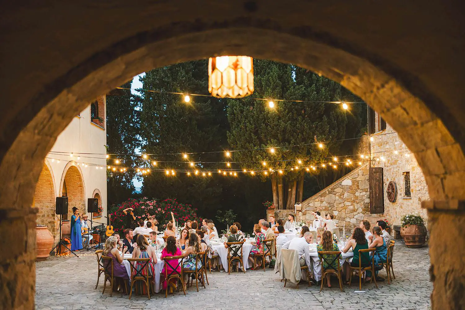 Relaxed countryside wedding dinner reception in the courtyard of Fattoria Agriturismo Quercia al Poggio