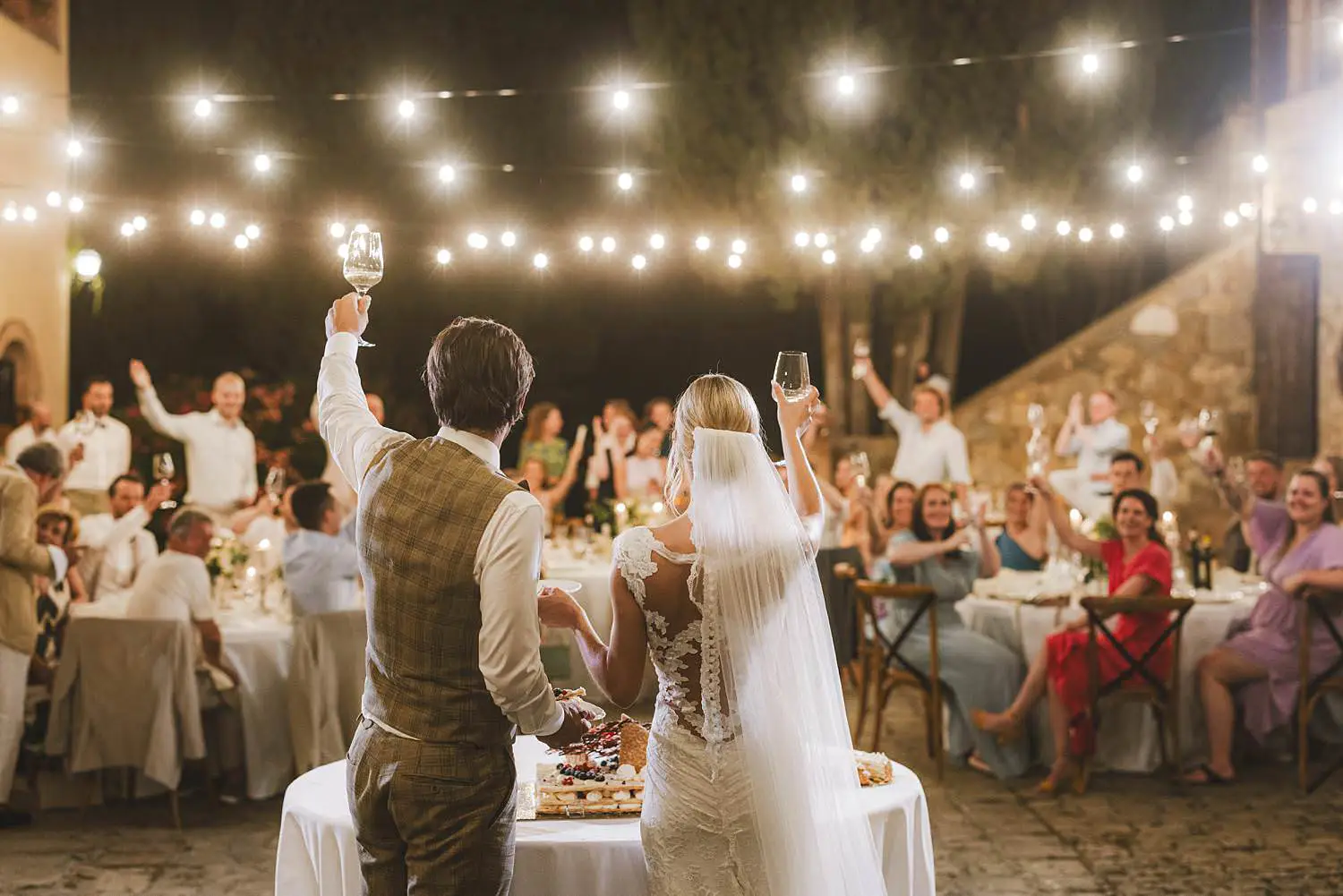 Timeless and unforgettable cut of the cake by bride and groom at courtyard of Agriturismo Quercia al Poggio wedding