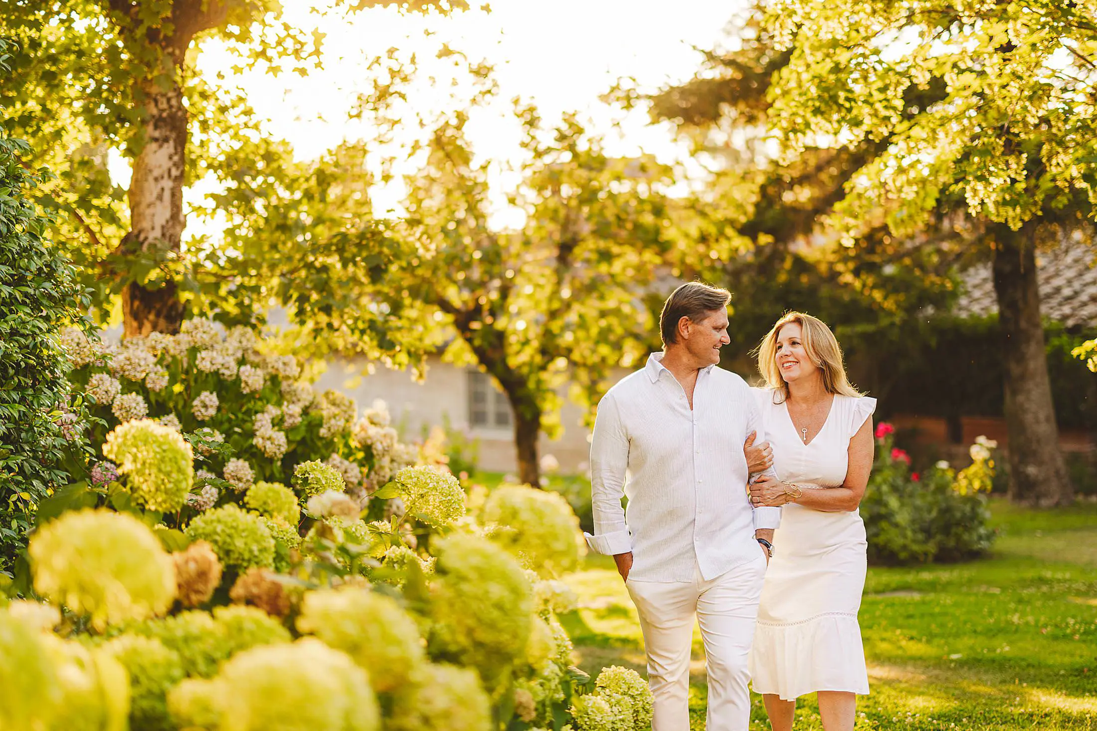Elegant and smiling couple during a family vacation photo shoot in Tuscany at Borgo San Felice under golden hour