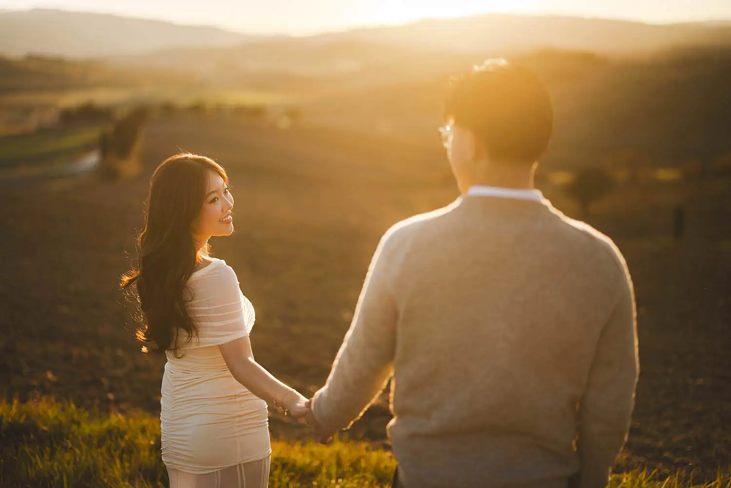 Elegant engagement photo shoot in the Tuscan countryside of Pienza at sunset with golden hour