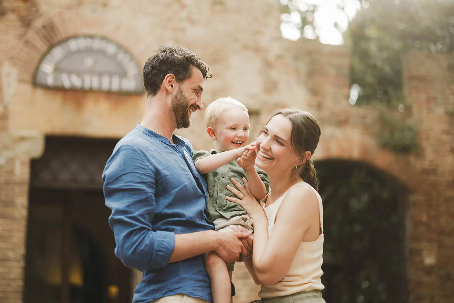 Joyful and smiling spontaneous family photos into Tuscan streets of Certaldo Alto village